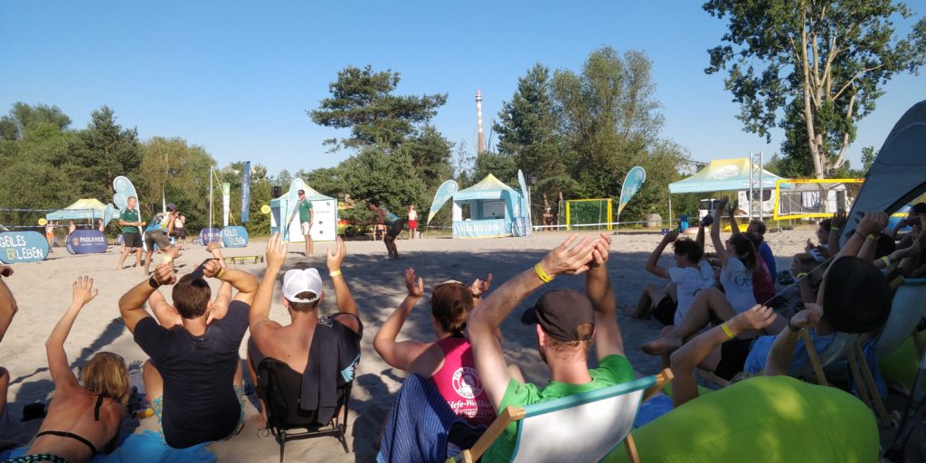 Gruppe von Menschen, die auf einer Sandsportanlage sitzen